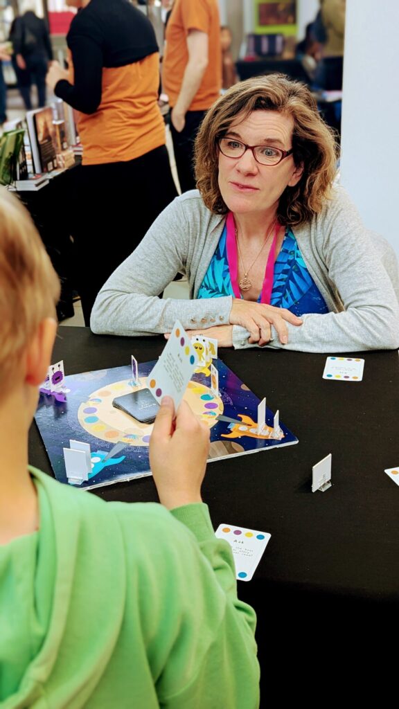 Nicci explaining Race To Your Rocket to a young player